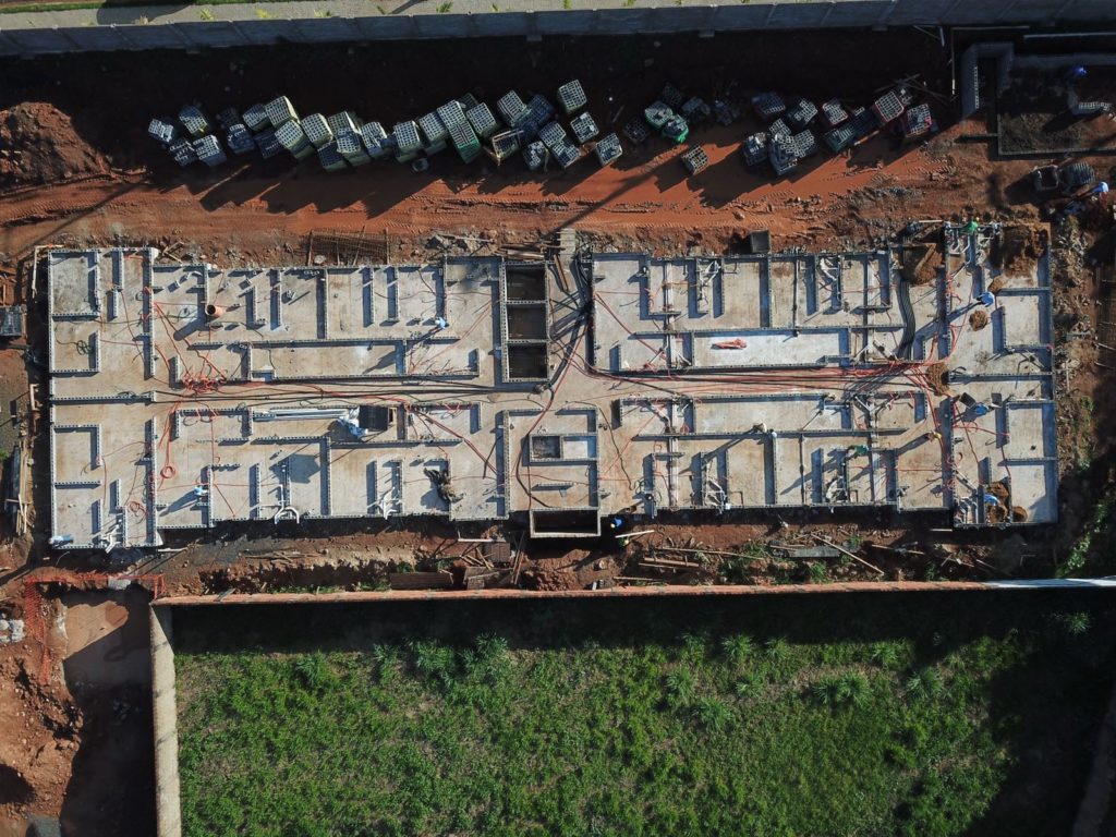 Execução de radier protendido em embasamento de torre residencial, com cabos de protensão posicionados antes da concretagem